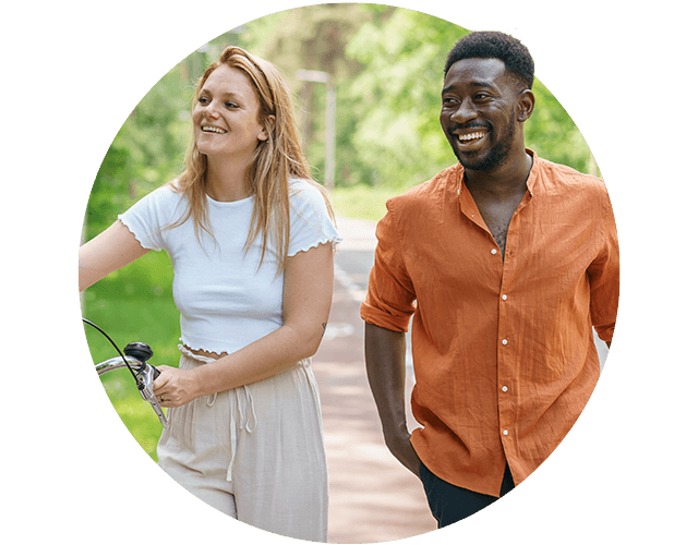 Jongen en meisje lopen door het park met fiets aan de hand