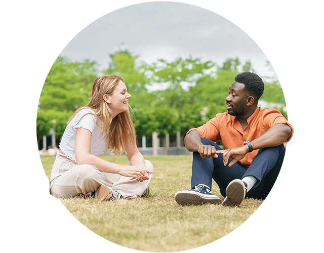 Een stel in een grasveld kletst met elkaar