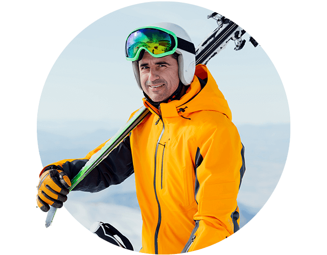 Man met ski outfit en ski's over schouder