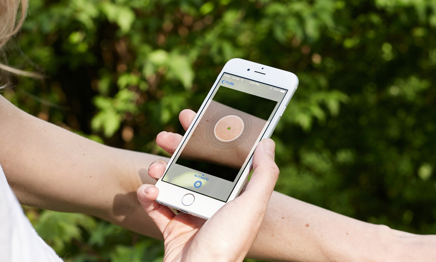 Vrouw checkt een verdacht vlekje op haar huid met SkinVision app