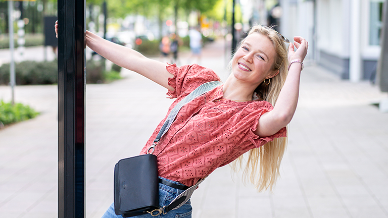 Meisje op straat bij lantaarnpaal